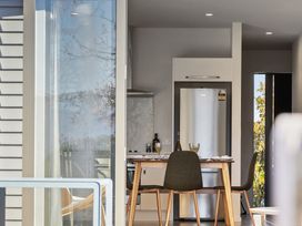 A kitchen with a table and refrigerator at Te Ohu - Wanaka Holiday Home Wanaka