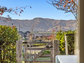 A view of mountains and trees from a garden at Te Ohu - Wanaka Holiday Home in Wanaka