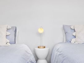 A bedroom with two beds and a lamp at Te Ohu - Wanaka Holiday Home in Wanaka
