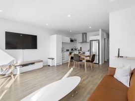 A living room with a television and kitchen area at Te Ohu - Wanaka Holiday Home in Wanaka