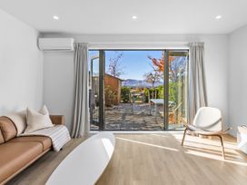 A living room with a sofa and sliding door at Te Ohu - Wanaka Holiday Home in Wanaka