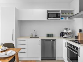 A kitchen with a sink, dishwasher, and coffee machine at Te Ohu - Wanaka Holiday Home in Wanaka