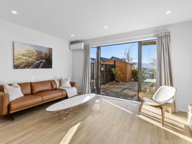A living room with a sofa and coffee table at Te Ohu - Wanaka Holiday Home in Wanaka