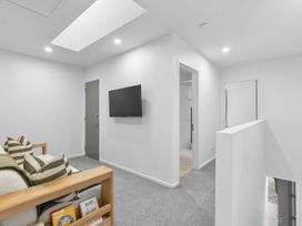 A living room with a television and sofa at Te Ohu - Wanaka Holiday Home in Wanaka