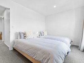 A bedroom with two beds and a lamp at Te Ohu - Wanaka Holiday Home, Wanaka