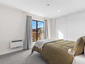 A bedroom with a bed and window at Te Ohu - Wanaka Holiday Home Wanaka