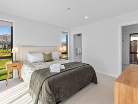 A bedroom with a bed and bedside table at Cromwell Holiday Home in Cromwell