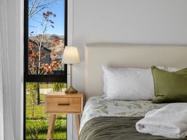 A bedroom with a bed and bedside table at Cromwell Holiday Home in Cromwell