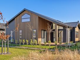 A modern house with trees and grass at Cromwell Holiday Home in Cromwell