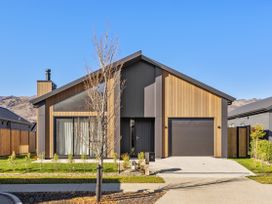 A house with a garage and trees at Cromwell Holiday Home in Cromwell