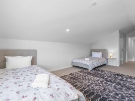 A bedroom with two beds and a lamp at Cromwell Holiday Home in Cromwell