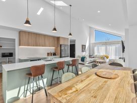 A kitchen and dining area with a large table and bar seating at Cromwell Holiday Home in Cromwell