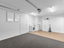 A laundry room with a washing machine and storage cabinet at Cromwell Holiday Home in Cromwell