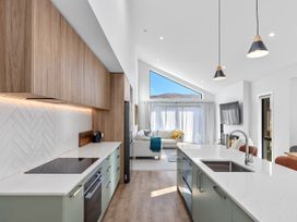A kitchen with cabinets and a stove at Cromwell Holiday Home in Cromwell