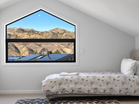 A bedroom with a bed and window at Cromwell Holiday Home in Cromwell
