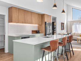 A kitchen with an island and bar stools at Cromwell Holiday Home in Cromwell