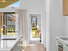 A kitchen with a sink and doorway leading to a bedroom at Cromwell Holiday Home in Cromwell