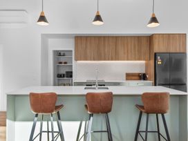 A kitchen with a countertop and stools at Cromwell Holiday Home in Cromwell