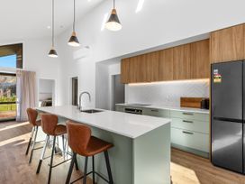 A kitchen with a large island and bar stools at Cromwell Holiday Home in Cromwell