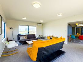 A living room with a sofa and coffee table at La Maison Bleu - Mangawhai Heads Holiday Home, Mangawhai