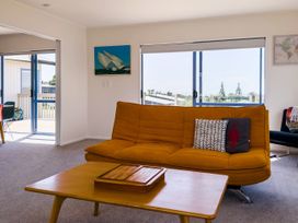 A living room with a sofa and table at La Maison Bleu - Mangawhai Heads Holiday Home, Mangawhai