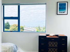 A bedroom with a window and a chest of drawers at La Maison Bleu - Mangawhai Heads Holiday Home, Mangawhai