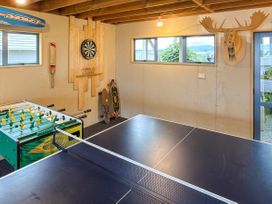 A game room with a table tennis table and foosball table at La Maison Bleu - Mangawhai Heads Holiday Home in Mangawhai