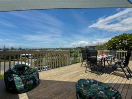An outdoor terrace with furniture and a view at La Maison Bleu - Mangawhai Heads Holiday Home Mangawhai