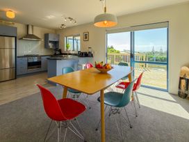 A kitchen with a dining table and chairs at La Maison Bleu - Mangawhai Heads Holiday Home, Mangawhai