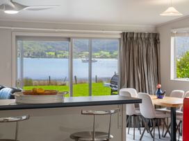 A dining room with a view of the lake and furniture at Picton Holiday Home in Picton