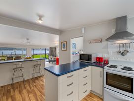 A kitchen with appliances and seating area at Picton Holiday Home in Picton