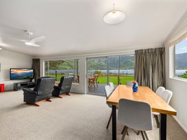 A living room with a tv and a dining table at Picton Holiday Home in Picton