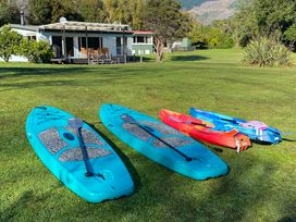 Kayaks and paddleboards on grass at Sounds Serenity - Marlborough Sounds Holiday Home, Queen Charlotte Drive