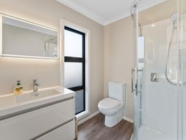 A bathroom with sink, toilet, and shower at Turangi Holiday Home in Turangi