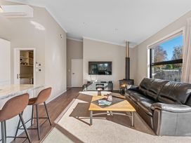 A living room with a sofa and television at Turangi Holiday Home in Turangi