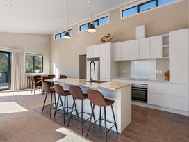 A kitchen with an island and stools at Turangi Holiday Home in Turangi