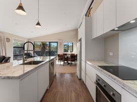 A kitchen with cabinets and dining area at Turangi Holiday Home in Turangi