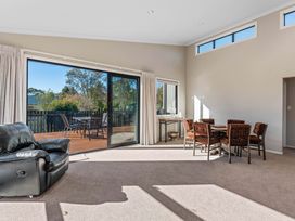 A living room with a sofa and dining area at Turangi Holiday Home in Turangi