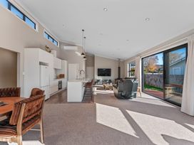 A living room with kitchen and dining area at Turangi Holiday Home in Turangi