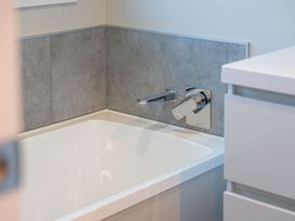 A bathtub with faucet and vanity in Turangi Holiday Home Turangi