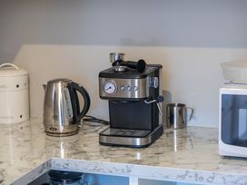 A kitchen with an espresso machine and kettle at Turangi Holiday Home in Turangi