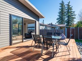 An outdoor deck with table and chairs at Turangi Holiday Home in Turangi