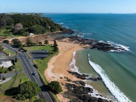 A beach with ocean and road at Bay View Escape - Cable Bay Holiday Home Cable Bay
