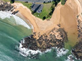 An aerial view of a beach with water and rocks at Bay View Escape - Cable Bay Holiday Home