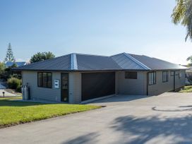 A modern house exterior with garage and lawn at Bay View Escape - Cable Bay