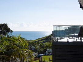 A view of the sea and deck with glass railing at Bay View Escape - Cable Bay