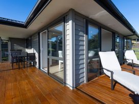 An outdoor seating area with a table and chairs at Bay View Escape - Cable Bay