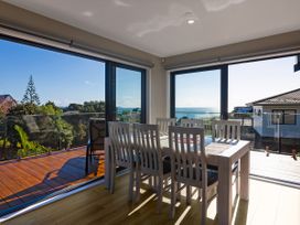 A dining room with a table and chairs at Bay View Escape - Cable Bay