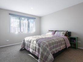 A bedroom with a bed and window at Bay View Escape - Cable Bay Holiday Home