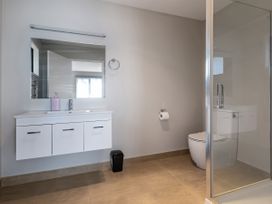 A bathroom with a sink, shower, and toilet at Bay View Escape - Cable Bay